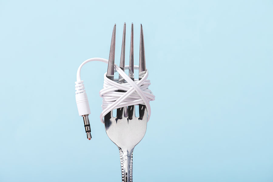 top-view-of-earphones-wrapped-over-metal-fork